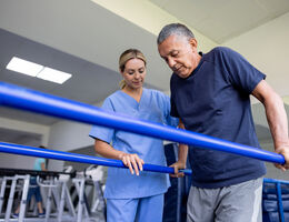  A physical therapist helping a patient walk.