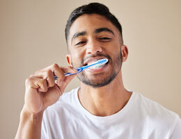 A man brushes his teeth.